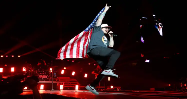 Morgan Wallen performing concert layring a flag
